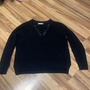 Thick black sweater that has ties on the front